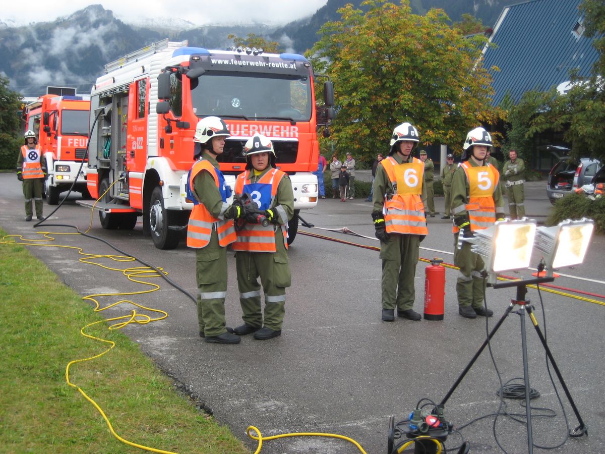 Zwei Feuerwehrautos und einige Feuerwehrmänner bei der Leistungsprüfung