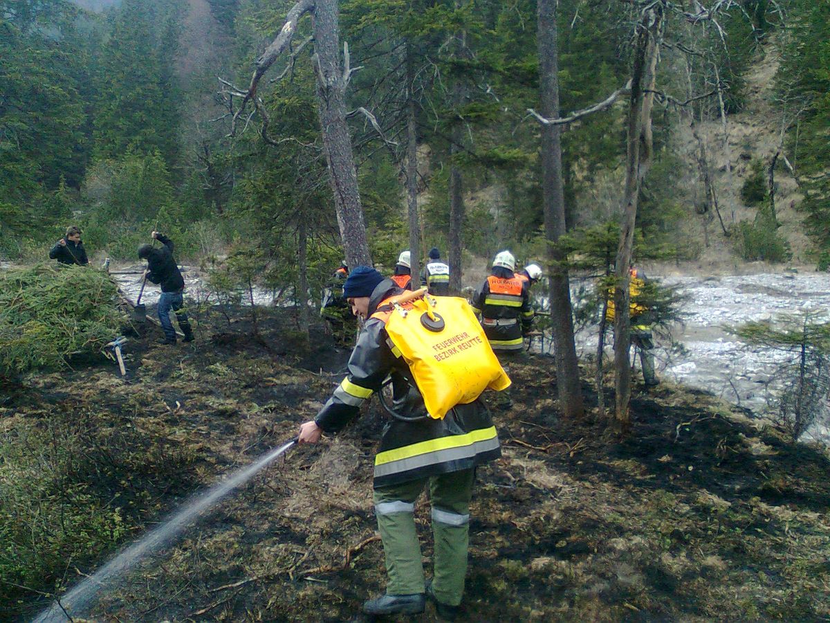 Feuerwehrmitglieder löschen mittels Löschrucksack die Glutnester