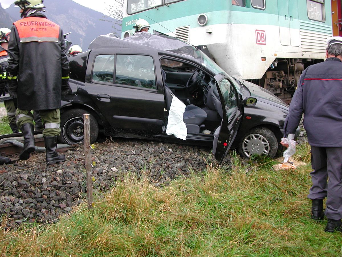 Deformierter PKW auf den Schienen der Bahn