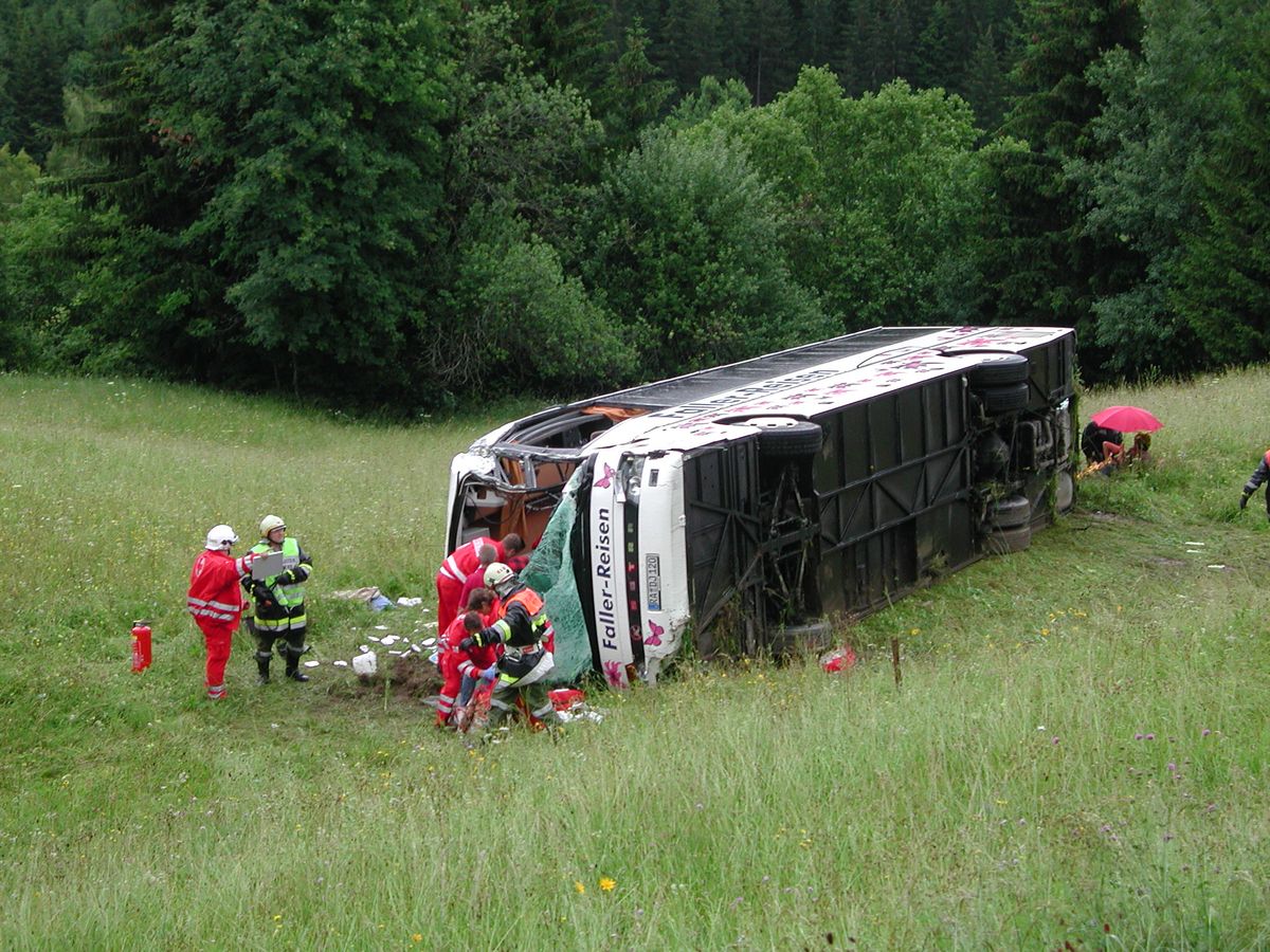 Reisebus liegt auf der Seite in einer Wiese