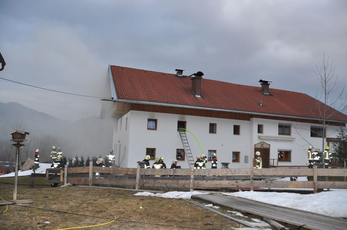 Mehrere Feuerwehrmitglieder vor einem Gebäude