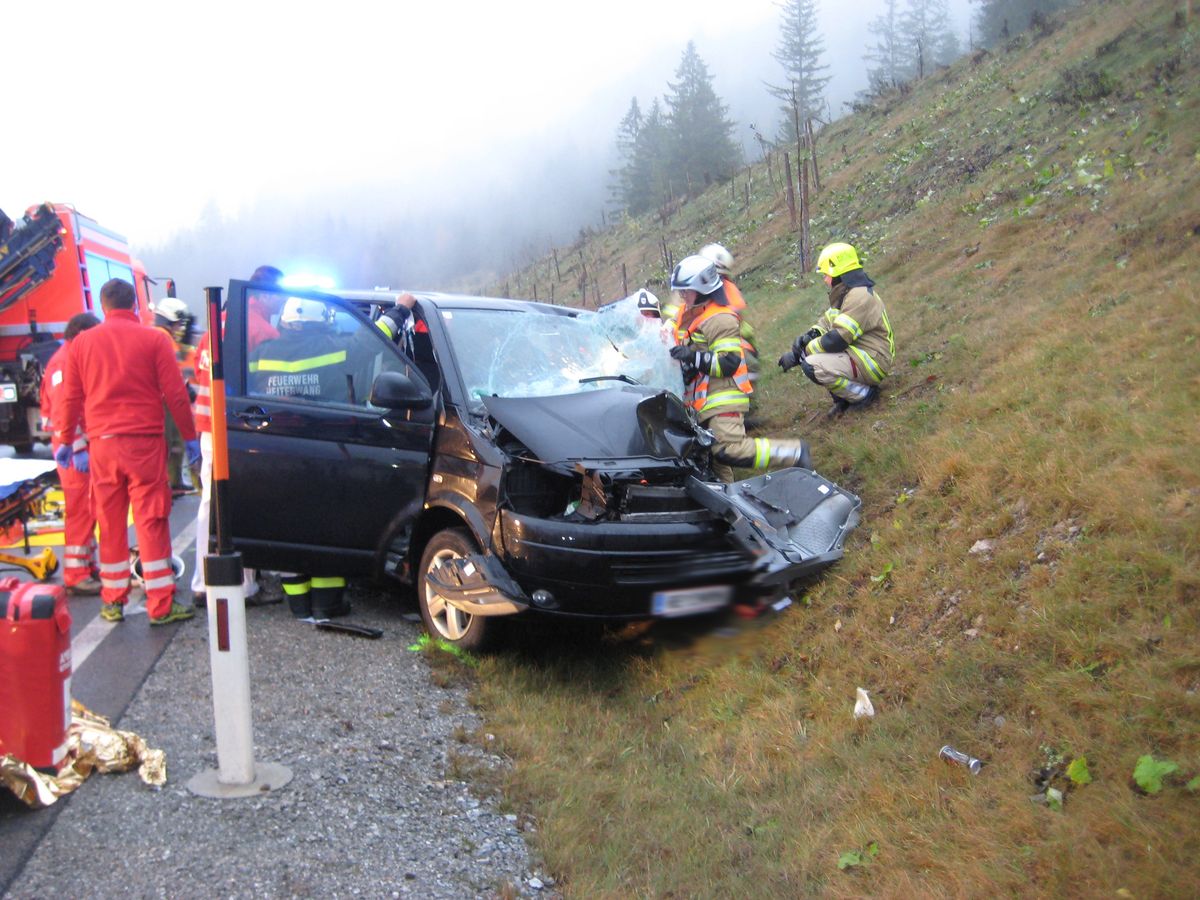 Mitglieder der Feuerwehr und des Rettungsdienstes an einem verunfallten Fahrzeug