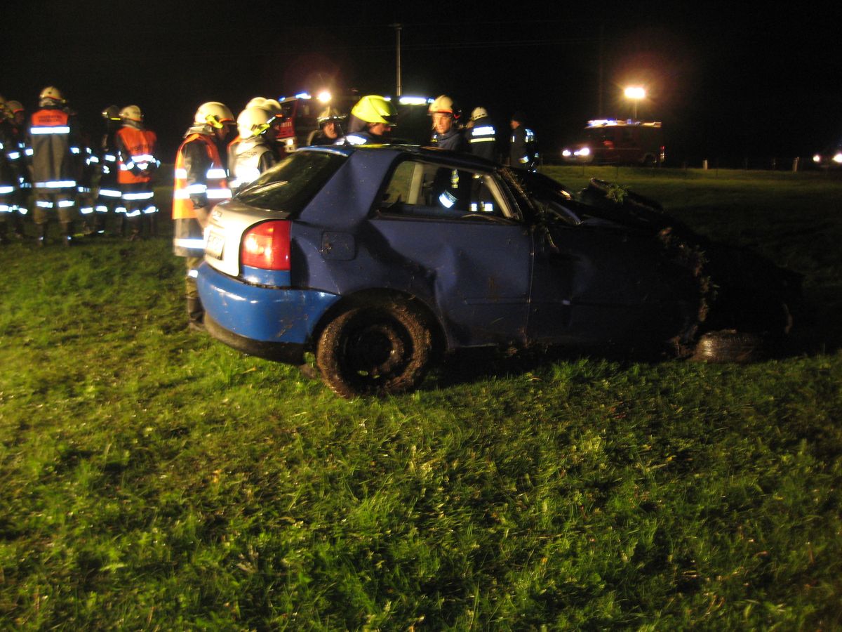 Beschädigter PKW neben der Straße in einem Feld