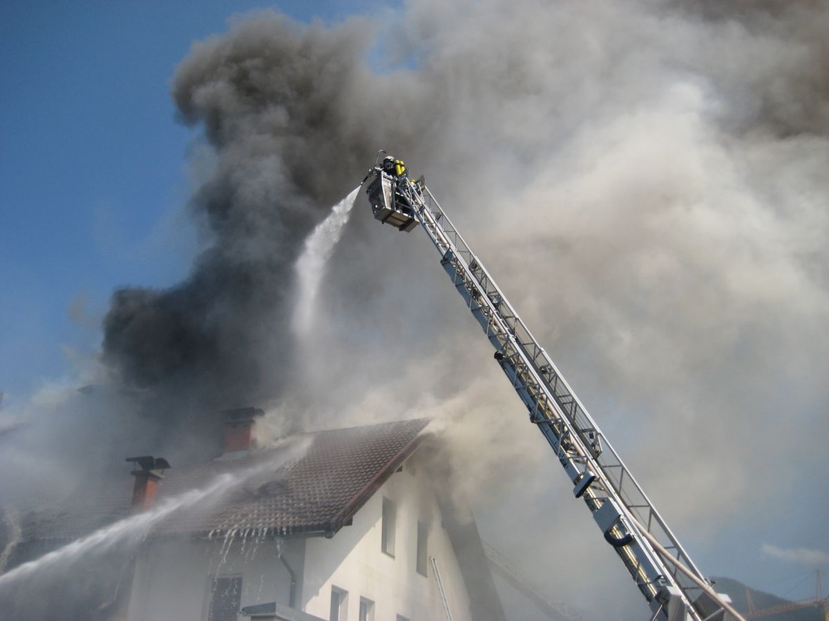 Dichter Rauch aus dem Wohnhaus. Mit der Drehleiter wird gelöscht.