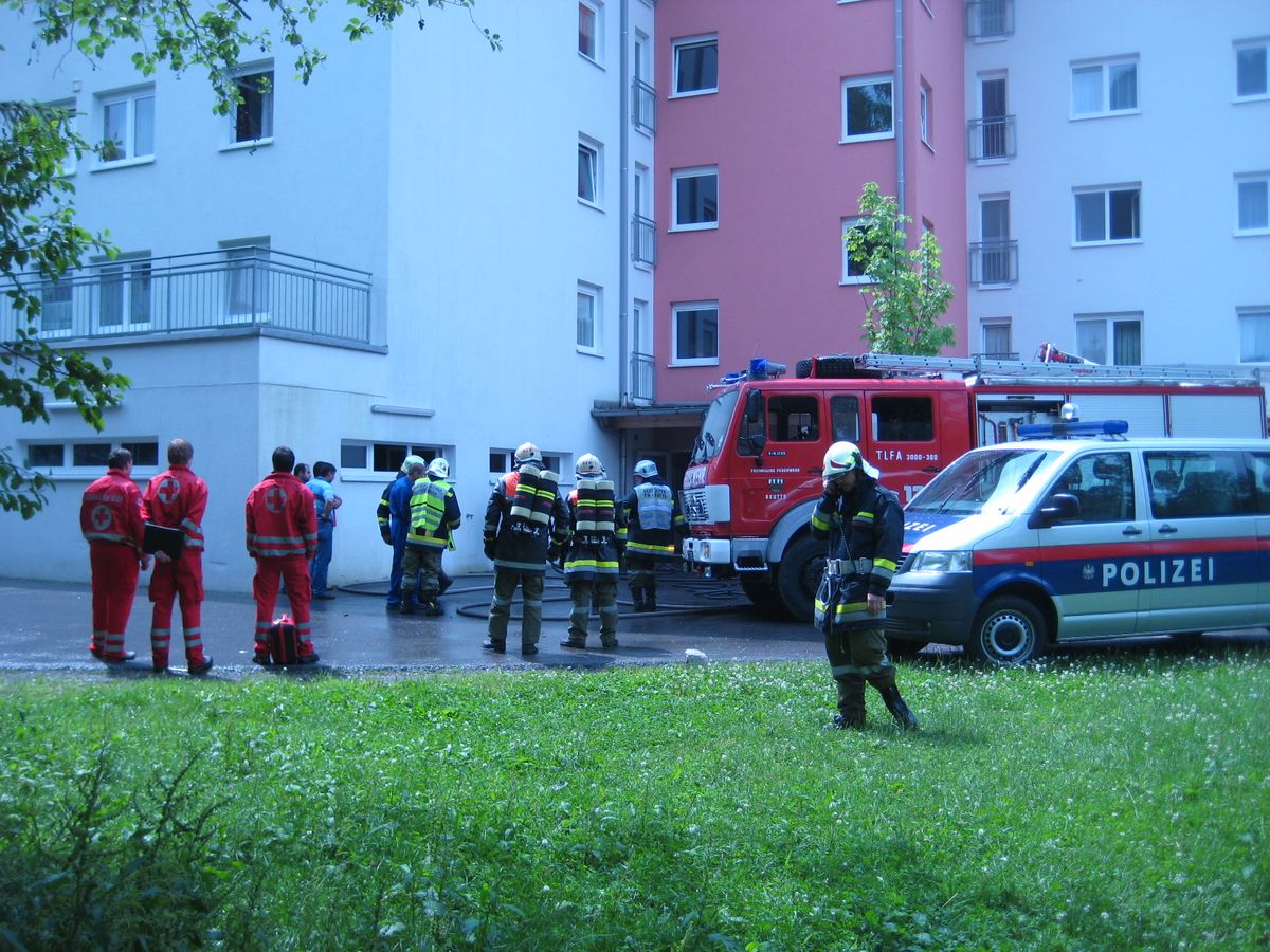 Mehrere Einsatzkräfte vor dem betroffenen Wohnblock