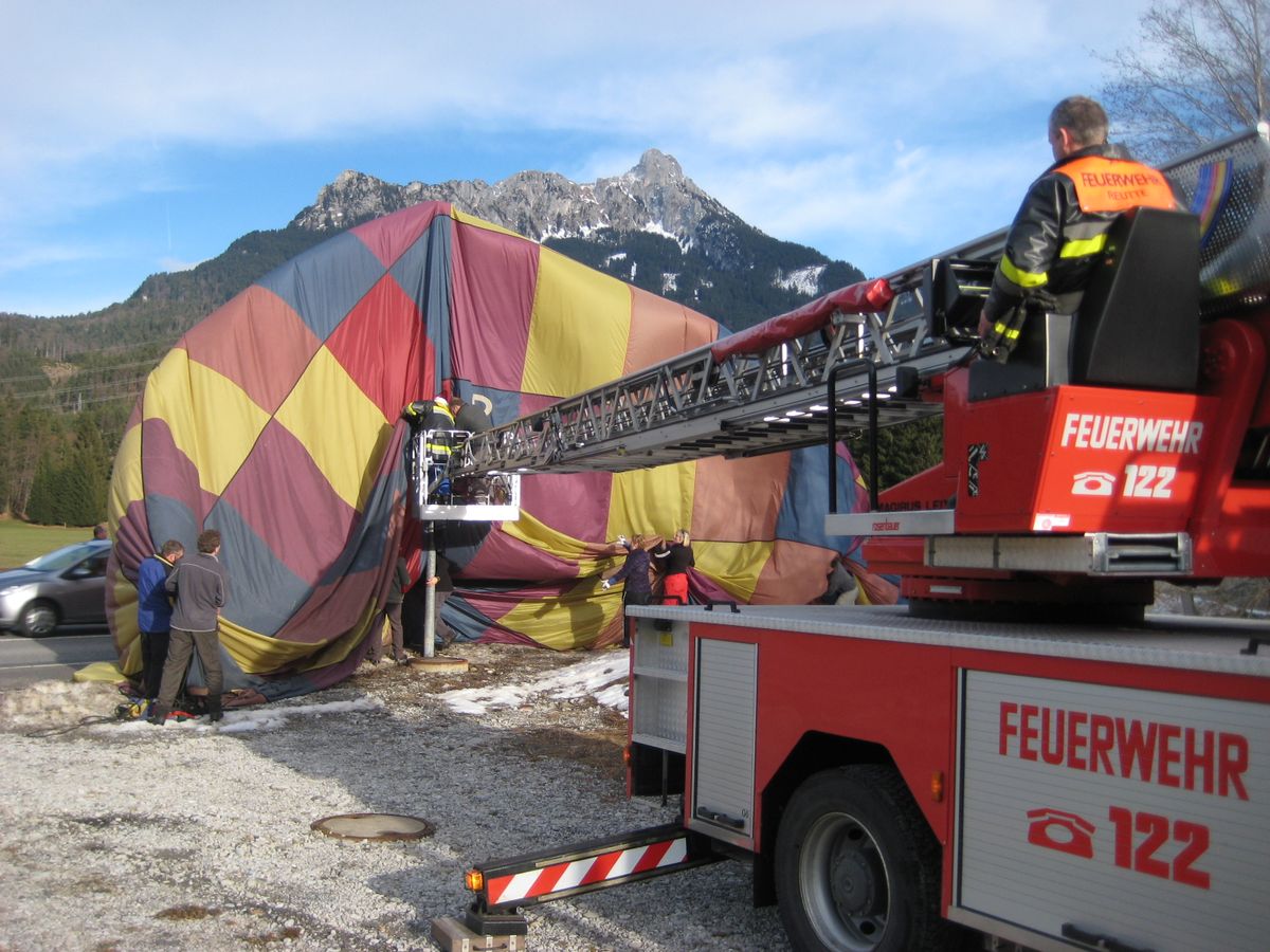 Mittels der Drehleiter wird der Heißluftballon von der Straßenlaterne entfernt